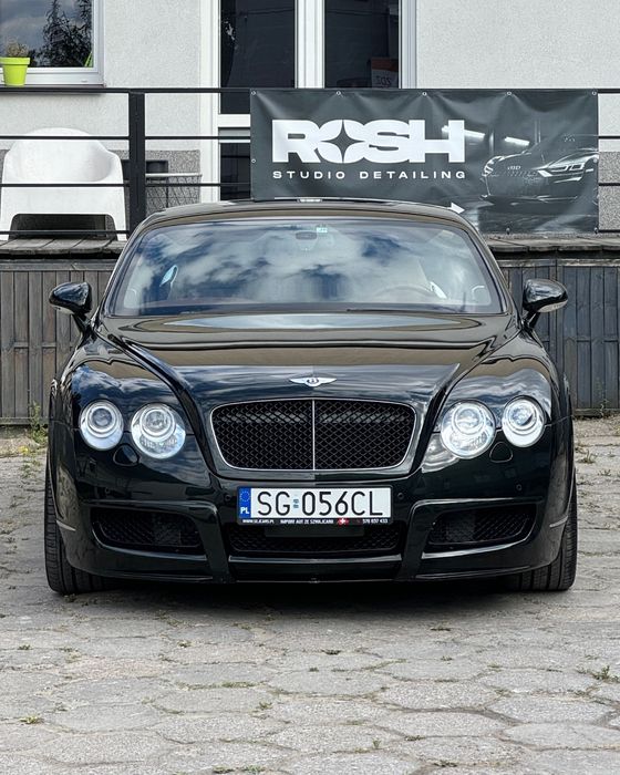 Bentley Continental GT przed studiem ROSH w Radomiu, w tle baner ROSH Studio Detailing